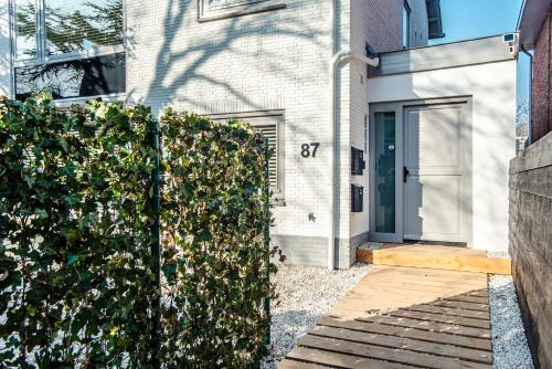 a fence in front of a house with a door at Marley’s Beachhouse - Luxury Guest Room with balcony in Zandvoort