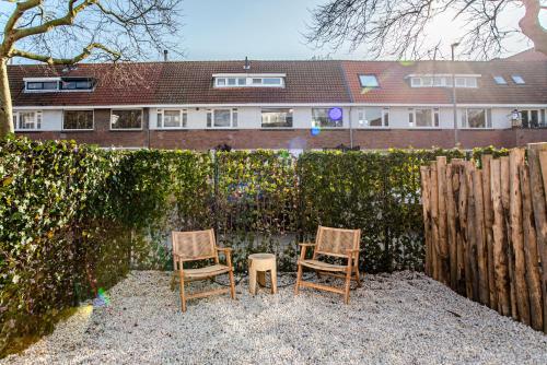 two chairs sitting in front of a fence at Marley’s Beachhouse - Luxury Guest Room with balcony in Zandvoort