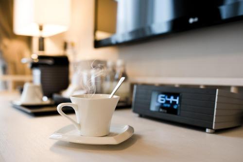 a cup of coffee on a counter with a clock at Hotel NuVe Heritage in Singapore