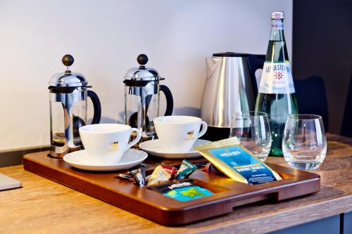 a tray with two cups and two glasses on a table at Logierhaus RheintorEins in Rees