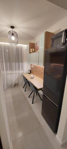 a kitchen with a table and a black refrigerator at University Apt in Baia Mare