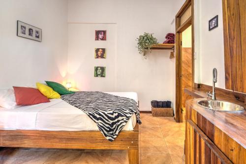 a small bedroom with a bed and a sink at Colibri Ecolodge 3 minutes walk to beach and town in Puerto Viejo