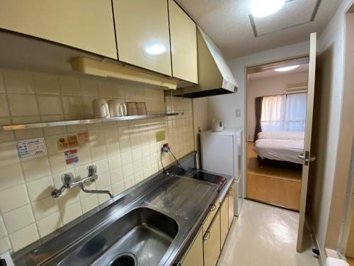 een kleine keuken met een wastafel en een koelkast bij Royal Heights Chuocho - Vacation STAY 12750 in Kagoshima