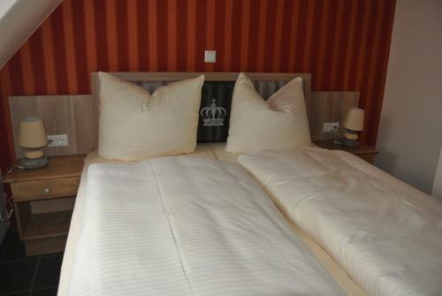 a large bed with white sheets and pillows at Haus Drei Könige in Balve
