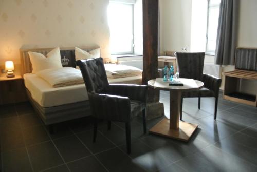 a bedroom with a bed and a table and chairs at Haus Drei Könige in Balve