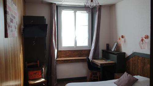Una televisión o centro de entretenimiento en Hotel Le Colibri