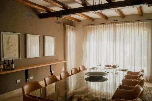 een eetkamer met een glazen tafel en stoelen bij Susana Balbo Winemaker´s House in Ciudad Lujan de Cuyo