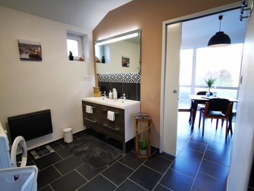 a bathroom with a sink and a mirror and a table at LE GAI LO GITE in Villers-Pol