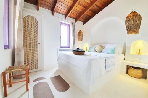 a white bedroom with a bed and a chair at Mor Panjurlu Bohem Tasarım Ev - Kazdağları & Deniz in Ayvacık