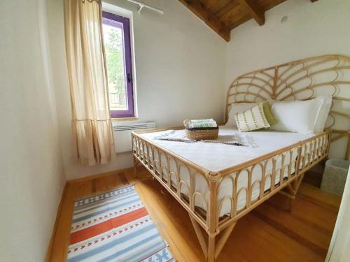 um quarto com uma cama grande num quarto com uma janela em Yerden Isıtma ve Şömineli Salvia - Sakin ve Bohem em Ayvacık