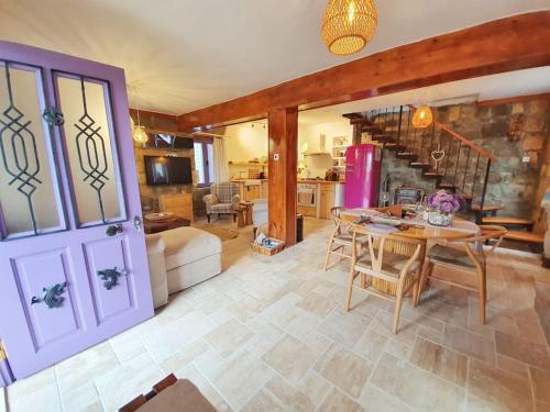 ein Wohnzimmer mit Tisch und Küche in der Unterkunft Mor Panjurlu Bohem Tasarım Ev - Kazdağları & Deniz in Ayvacık