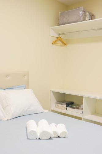 a white bed with three folded towels on it at Apê Jabuticabeira in Pomerode