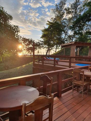 a deck with tables and chairs and a gazebo at Hotel and Dive Center Roatan Yacht Club in Roatán