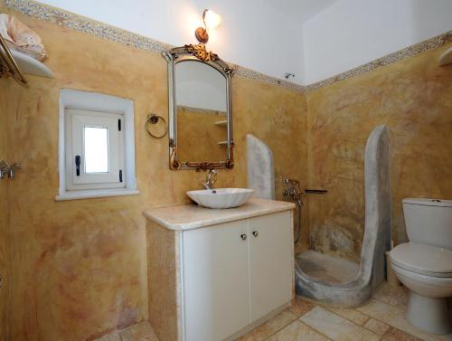 a bathroom with a sink and a toilet at Paros Afrodite Luxury Villas in Aliki