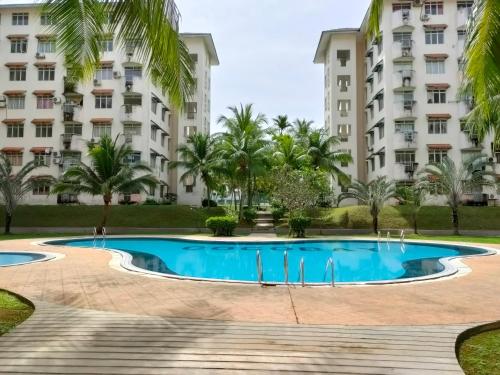 a swimming pool in front of a building at Deluxe Family Beach Condo PortDickson in Port Dickson