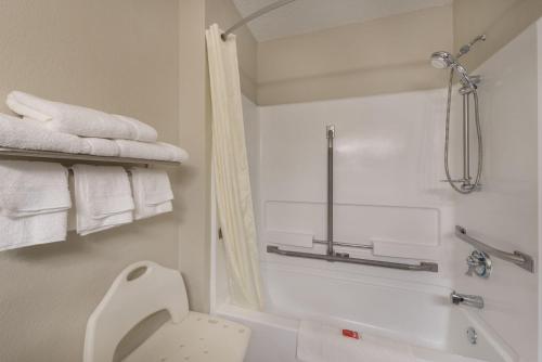y baño con aseo y ducha con toallas. en Harmony Inn, en New Ulm