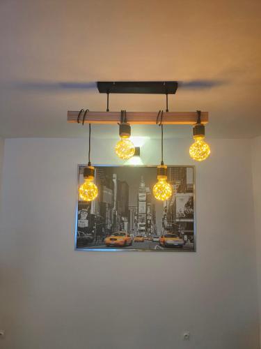 a group of lights hanging from a wall with a picture at Les Lofts De Provins: Apt 1 in Provins