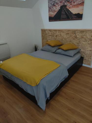 um quarto com uma cama com um cobertor amarelo em Les Lofts De Provins: Apt 1 em Provins