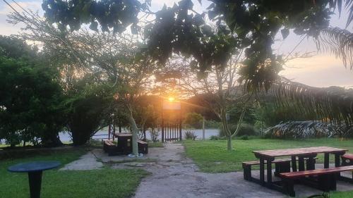 a group of picnic tables in a park with the sunset at Sunset Bed and Breakfast in Coffee Bay