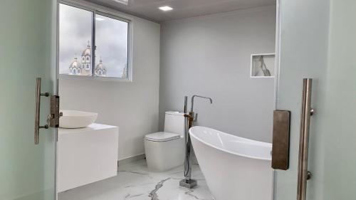 a white bathroom with a sink and a toilet at Penthouse - Vista Hermosa Apartments in Filandia