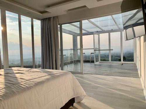 1 dormitorio con 1 cama y grandes ventanas de cristal en Penthouse - Vista Hermosa Apartments, en Filandia
