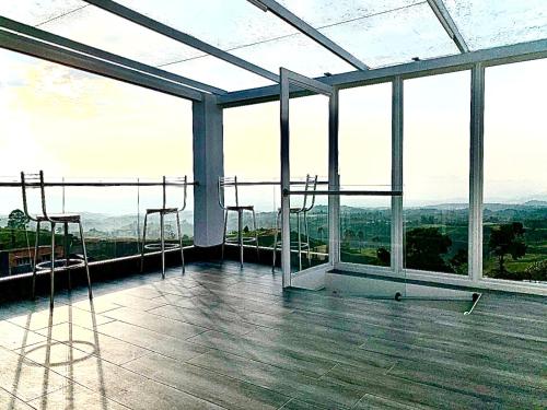 a large room with windows and stools on a roof at Penthouse - Vista Hermosa Apartments in Filandia