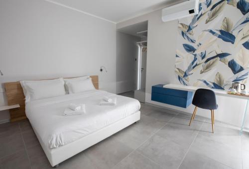 ein Schlafzimmer mit einem weißen Bett und einer blau-weißen Tapete in der Unterkunft B&B Fior di Magnolia in Moniga