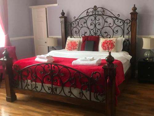 a bed that has a red blanket on it at Kempfield House in Brighton & Hove