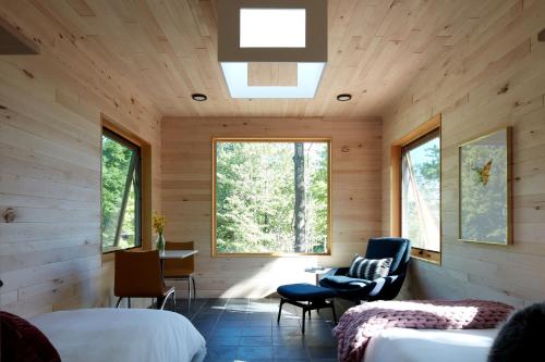 1 dormitorio en una cabaña de madera con 2 camas y ventanas en Wild Rice Retreat, en Bayfield