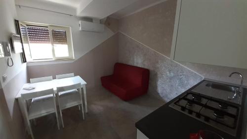 una pequeña cocina con una silla roja y una mesa en Casa vacanze Sabin, en Polignano a Mare
