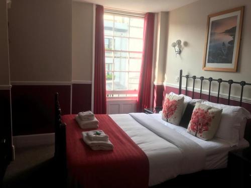 1 dormitorio con 1 cama grande y toallas. en Kempfield House, en Brighton & Hove