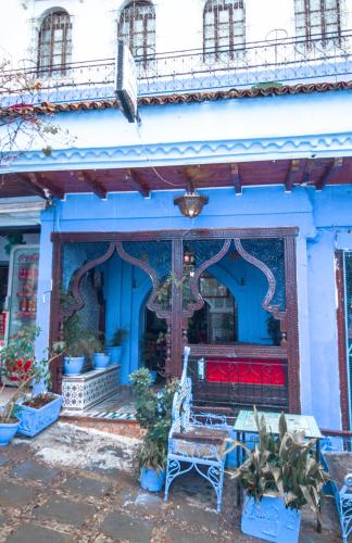 a blue building with a bench in front of it at Hotel Al kassaba in Chefchaouene