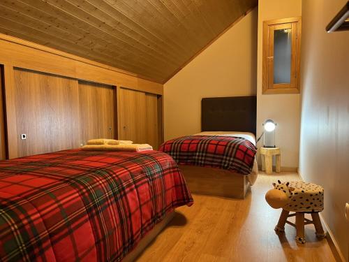 a bedroom with two beds and a wooden ceiling at Estrela da Montanha in Penhas da Saúde