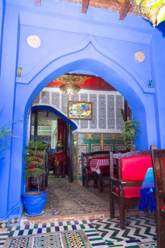 a blue room with a table and chairs in it at Hotel Al kassaba in Chefchaouene
