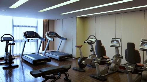 a gym with treadmills and ellipticals in a room at Melia Jinan in Jinan
