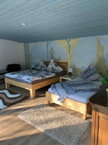 two beds in a room with a mural on the wall at Gästezimmer am Waldrand in Leimbach