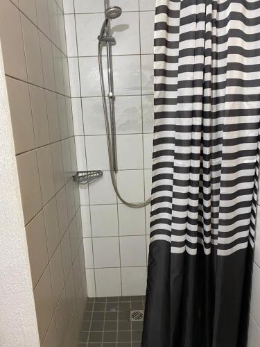 a shower with a black and white shower curtain at Gästezimmer am Waldrand in Leimbach