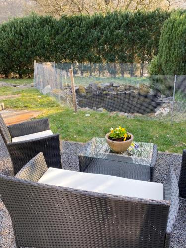 a table and chairs with a bowl of flowers on it at Gästezimmer am Waldrand in Leimbach
