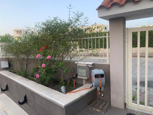 a utility box on a wall with flowers and a fence at ISCA BLUE BEACH Casa in Villa vicino al mare, sino a max 8 persone in Isca sullo Ionio