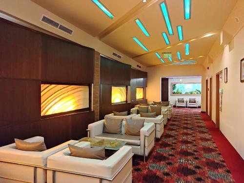 a waiting room with white couches and a red carpet at Spa Residence Carbona Apartment 105 in Hévíz