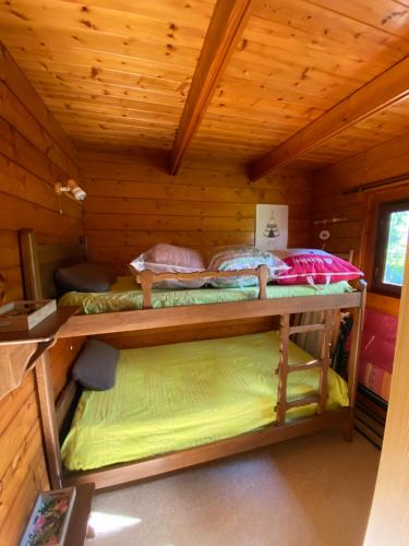 a room with two bunk beds in a cabin at Maison 2 chambres proche Dijon chalet niché dans la nature in Saint-Maurice-sur-Vingeanne