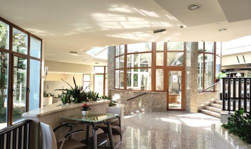 a lobby with a table and some windows at Spa Residence Carbona Apartment 105 in Hévíz