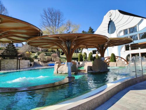 a swimming pool with an umbrella in the water at Spa Residence Carbona Apartment 105 in Hévíz