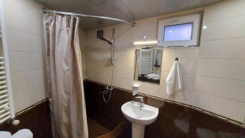 a bathroom with a toilet and a sink and a tv at Hotel Visitor in Mtskheta