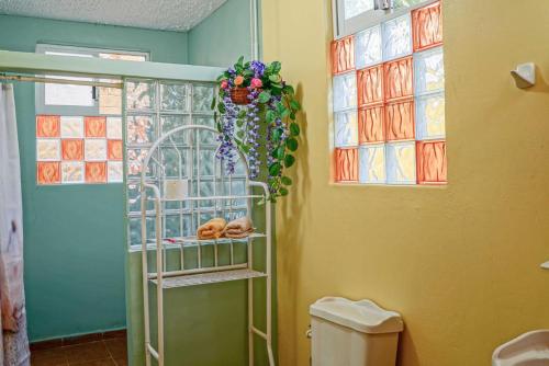 ein Badezimmer mit Toilette und Fenster in der Unterkunft Villas La Bella Margarita in Brisas de Zicatela