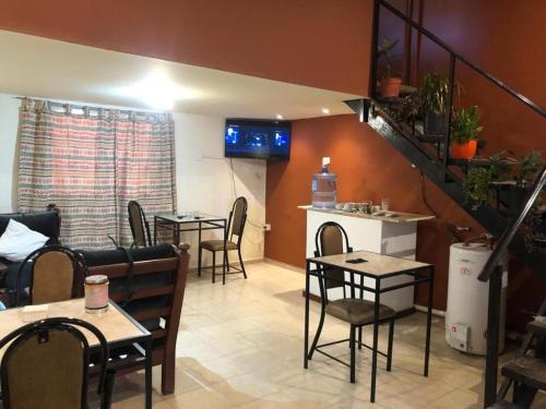 a restaurant with tables and chairs and a staircase at Posada El Paiman in Chilecito