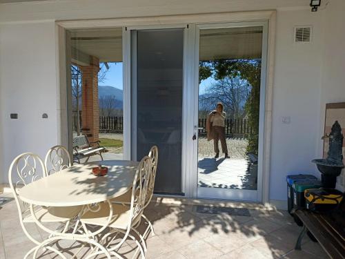 a person standing on a patio with a table and chairs at RossoMattone CountryHouse in Sulmona