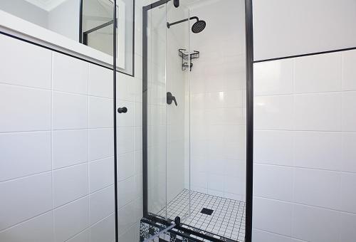a bathroom with a shower with a glass door at Modern Studio Apartment in Blouberg in Cape Town