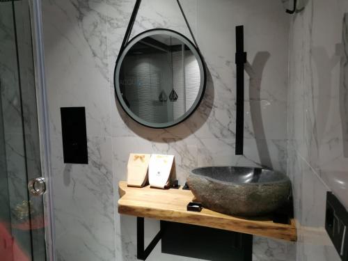 Un baño con un lavabo de piedra y un espejo. en Lexury Suite Acqua, en Babilafuente