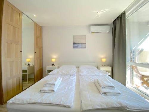 a large white bed in a room with a window at Paradiso Aparthotel - Private apartment -BSR-2 in Nesebar